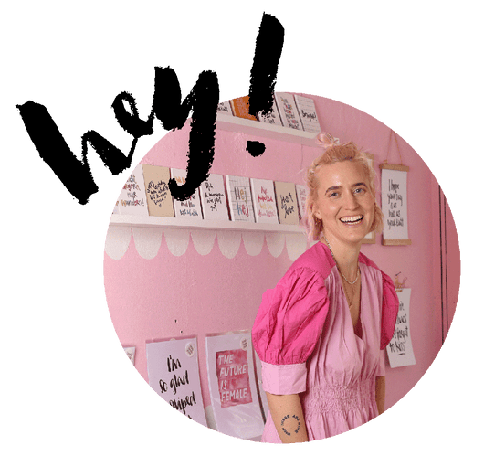 brushmeetspaper Gründerin Verena Prechsl in rosa Kleid in ihrem Store plus das Wort von Hand gelettert "hey!"